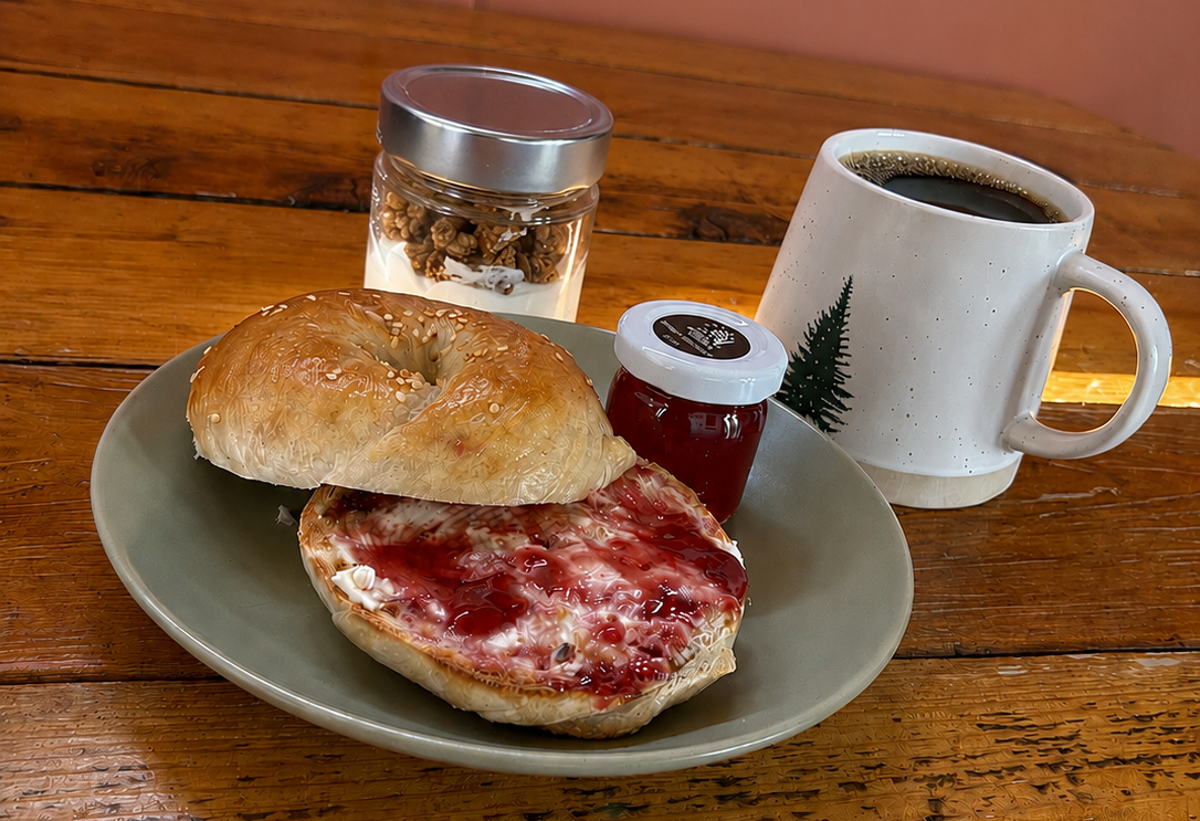 photo of a bagel, jam, coffee and yogurt at a cabin